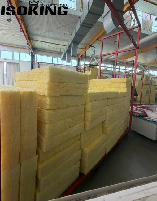 Warehouse storage of IKING yellow glass wool batt insulation, multiple packages of fiberglass batts arranged on pallets, showcasing professional insulation material manufacturing and export capability