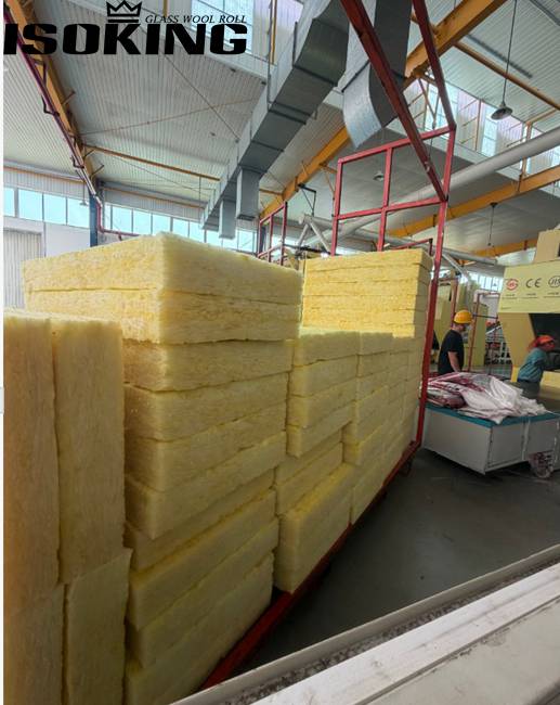 Close-up view of IKING yellow glass wool batts with clear packaging labels in a warehouse, demonstrating premium fiberglass insulation quality, soft fiber structure, and reliable product supply