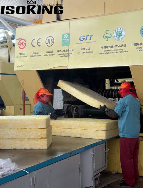IKING factory warehouse displaying yellow glass wool batt insulation rolls and batts, professional storage area with packaged fiberglass insulation products for overseas customers