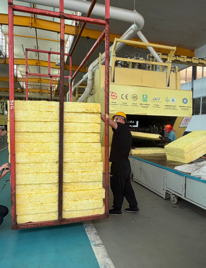 Workers inspecting high-density 6 inch fiberglass batt insulation packages before container loading