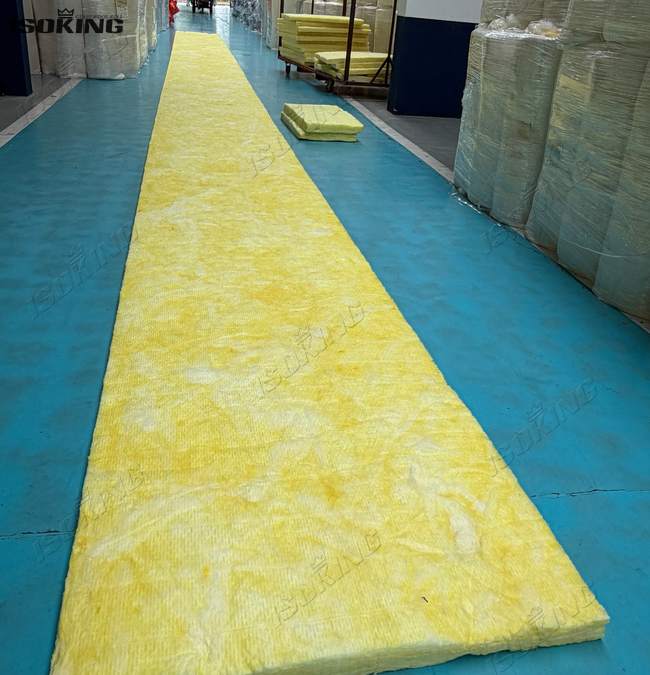 Factory technician measuring the total roll length of foil backed fiberglass insulation prior to packaging.