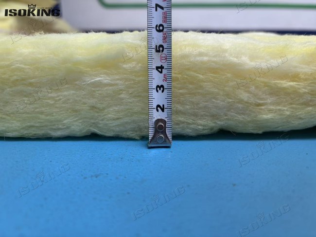 Precision thickness measurement of foil backed fiberglass insulation using a digital gauge.